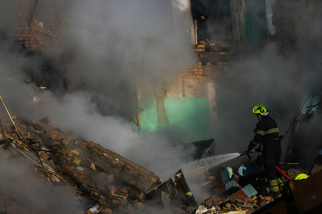 A firefighter works through thick smoke at the ruins of a residential building in Kyiv destroyed by a missile strike on 28 August.